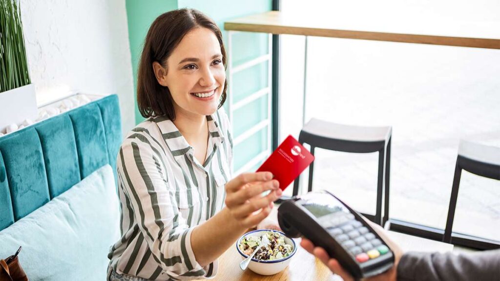 Een vrouw gebruikt ecocheques als extralegaal voordeel en draagt bij aan de lokale en duurzame economie.