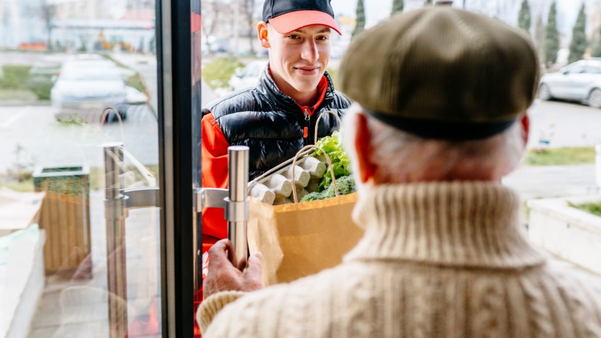 Een huishoudhulp brengt boodschappen binnen bij een gezin.