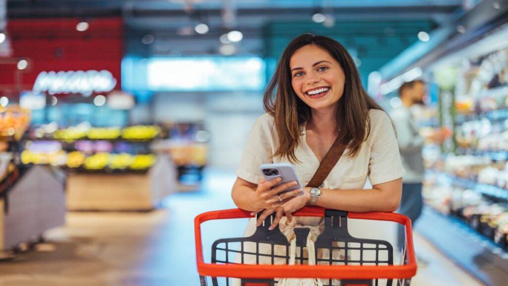 Een vrouw rekent haar boodschappen af in de supermarkt met maaltijdcheques.